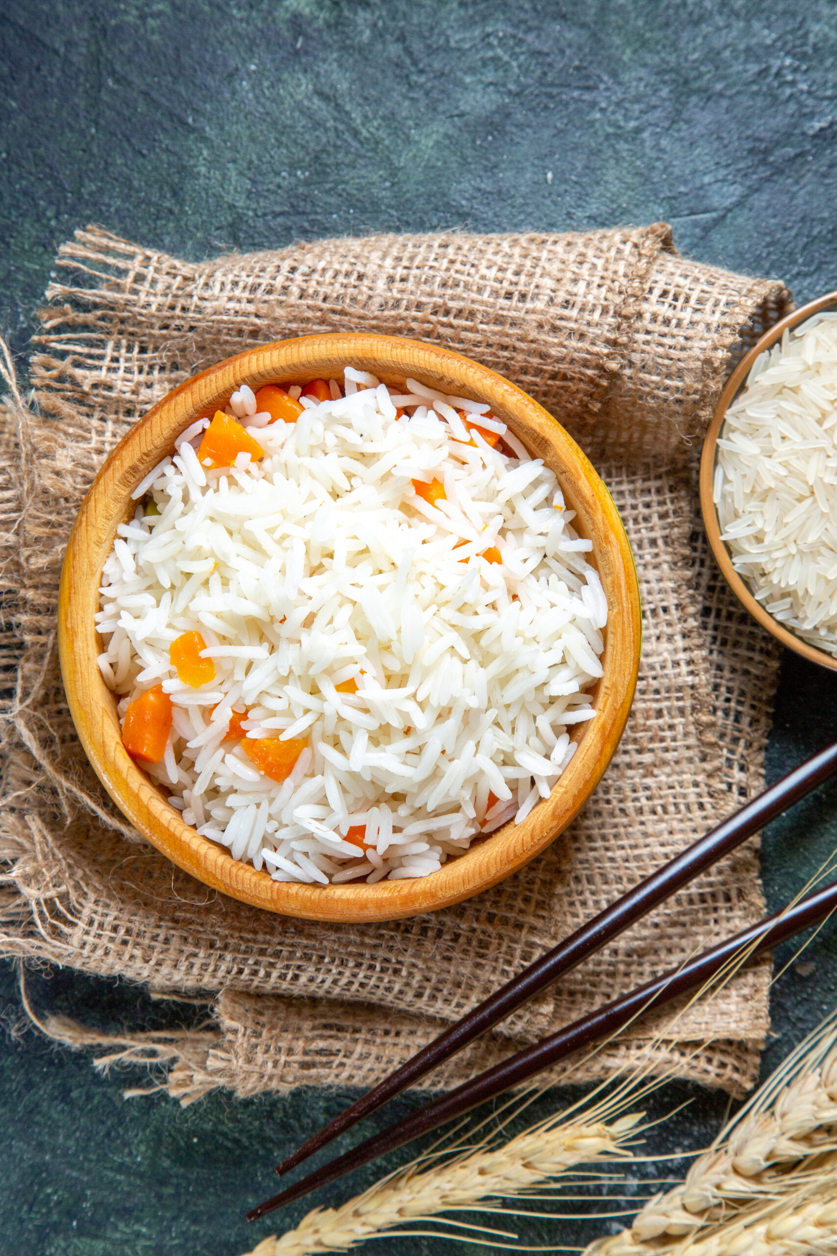 top-view-delicious-boiled-rice-with-raw-rice-inside-little-plate-dark-desk